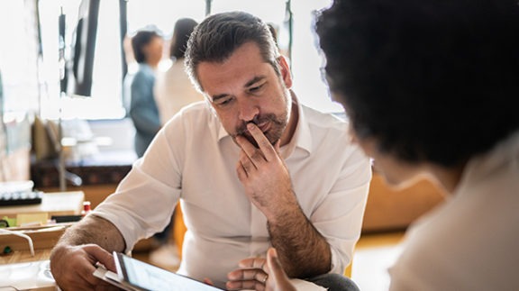 man looking at tablet with another person