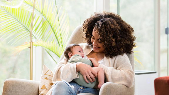 smiling woman holding child in arms