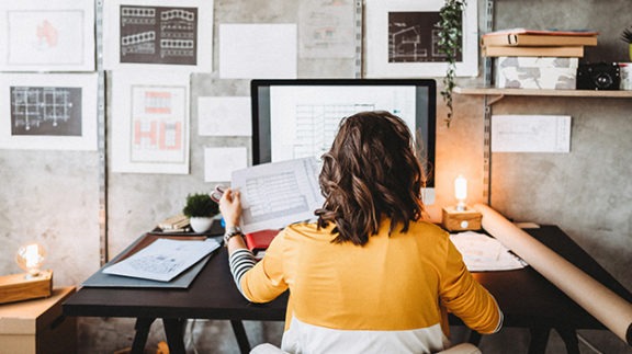 woman facing computer screen at desk