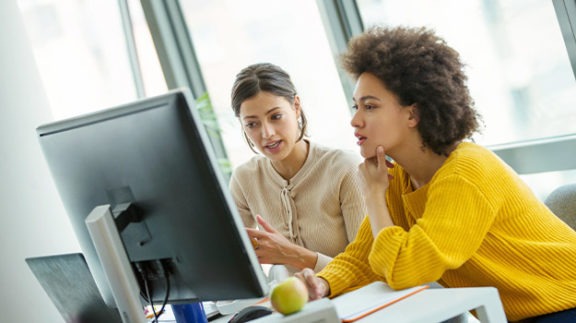 two professional women reviewing a computer screen