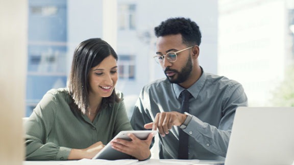 two professional conferencing over an ipad at a table