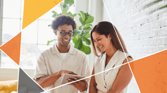 man and woman in white laughing at an ipad