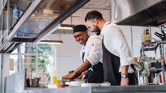 two cooks working in restaurant kitchen