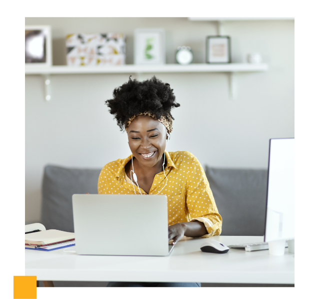 smiling woman sitting at desk with laptop