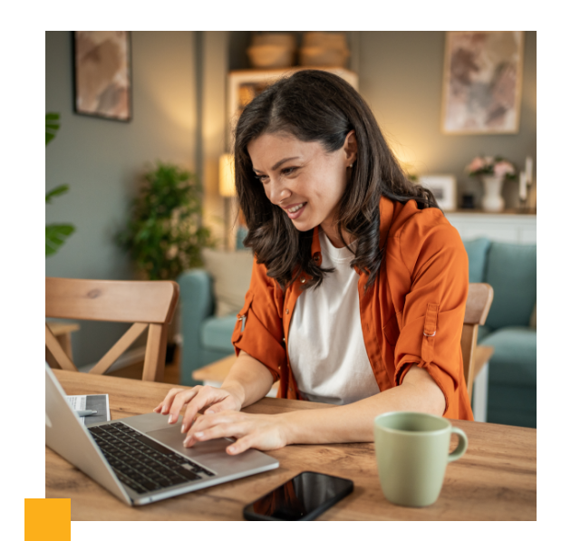 smiling woman using laptop in coffee shop