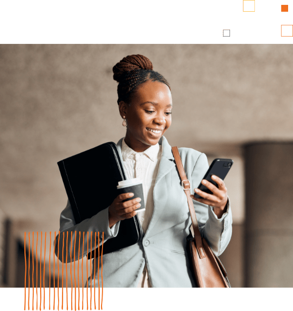 woman in business attire looking at phone, carrying coffee